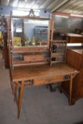 A late 19th Century oak dressing table in the Liberty style with adjustable mirror over a small