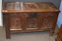 An 18th Century oak coffer with three panelled front decorated with carved and inlaid detail,