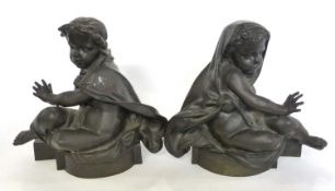 Two large bronze figures of cherubs mounted on semi-circular bases, 28cm high