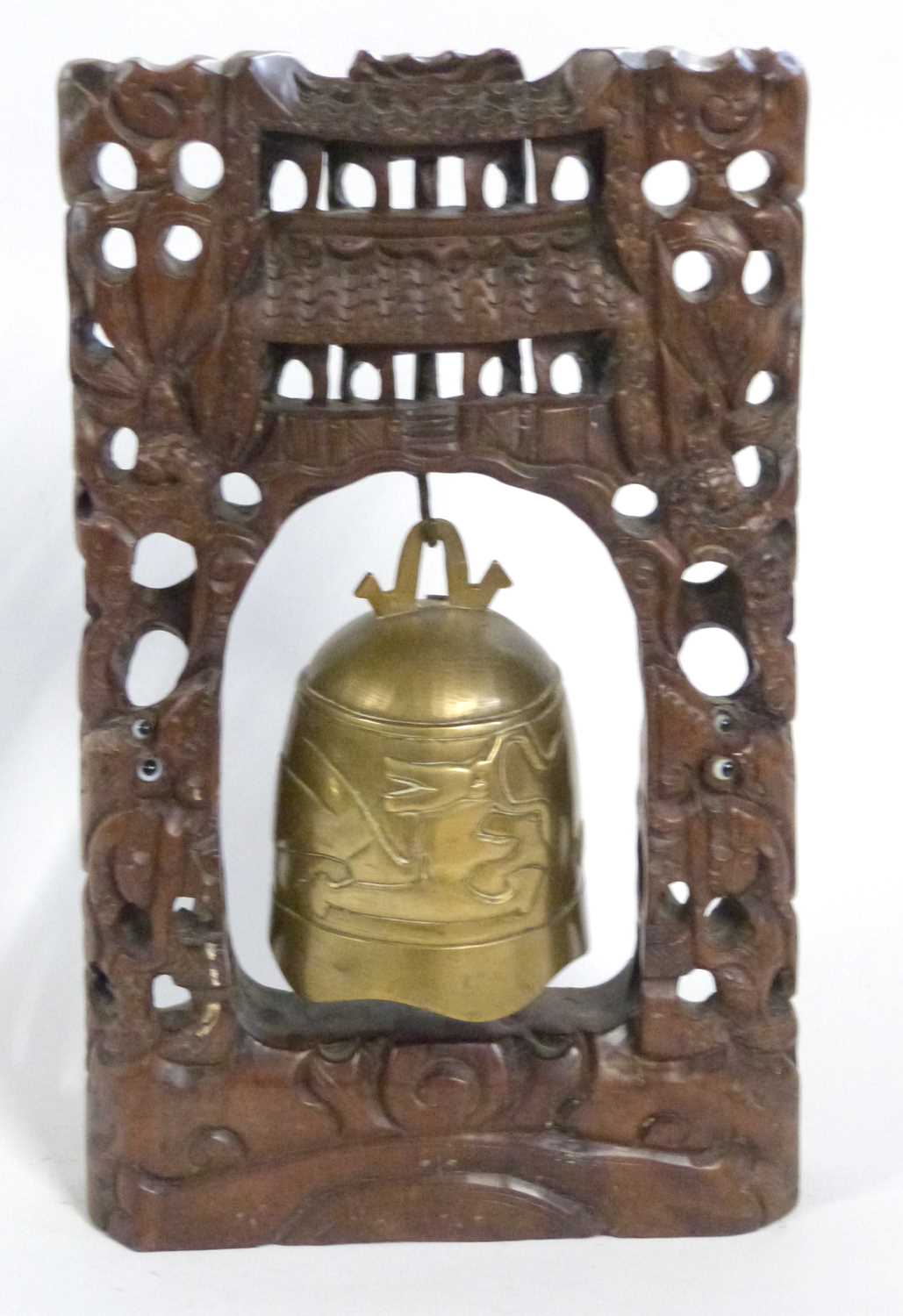 Chinese temple bell, the brass bell mounted on carved wooden rectangular mounts, 35cm high