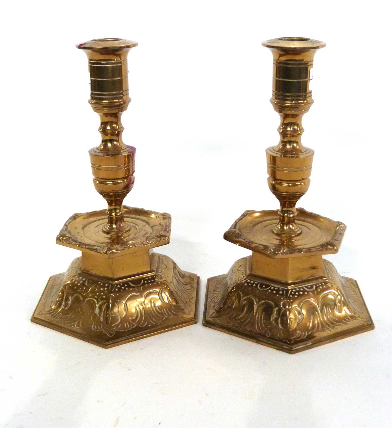 A pair of Swedish Ystad metal brass candlesticks decorated in medieval style, 22cm high