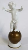 A Neu Tettau continental porcelain model of a cherub standing on a gilt coloured globe, factory mark