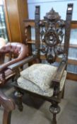 A Victorian dark gothic oak throne type chair with pierced foliate carved back with mask centre,