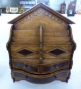 An unusal oak and mahogany table top stationery cabinet with gothic arched back and three small