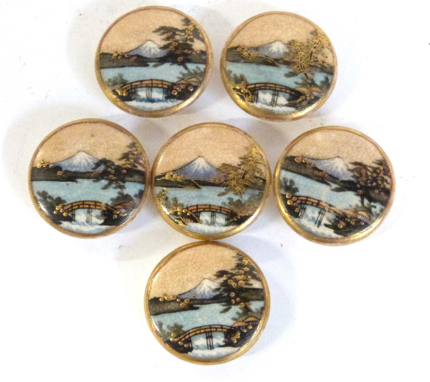 A small bag containing five Japanese Satsuma ware buttons, all decorated with views of Mount Fuji