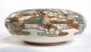 A Japanese Satsuma ware circular box and cover, the cover decorated with immortals in gilt and