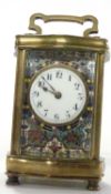 A 20th century brass cased carriage clock with unsigned coloured enamel decorated face .- 15 cm high