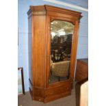 A late 19th Century mahogany wardrobe of unusual form with a moulded cornice, a central mirrored