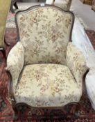 A 19th Century French armchair with floral upholstery and scroll finish feet, 90cm high, 70cm wide
