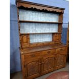 A good quality oak dresser with back section with two shelves and a selection of small drawers and