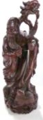 A Chinese wooden carving of an immortal on carved rocky base, 40cm high