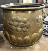 Circular brass jardiniere decorated with heraldic detail and lions head handles (lacking