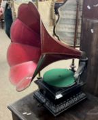 Table top gramophone with ebonised wooden body and a red metal horn