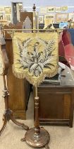 Victorian brass and hardwood pole screen mounted with a shield shape beadwork panel, 144cm high