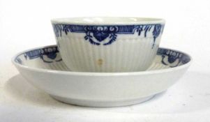 A Worcester tea bowl and saucer with a reeded shape, blue and white design