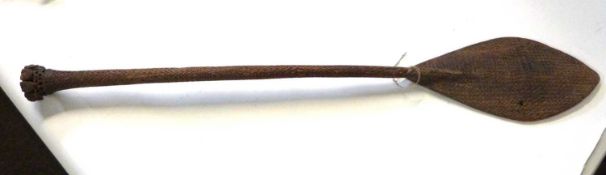 Antique tribal paddle, the hardwood body decorated with an intricately carved design, 93cm long