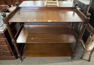 20th century mahogany veneered three tiered dumb waiter raised on brass casters, 100cm wide