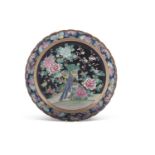 A Japanese porcelain famille noir charger Meiji period decorated with a pheasant and flowers