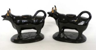 A pair of Jackfield type black and gilt cow creamers