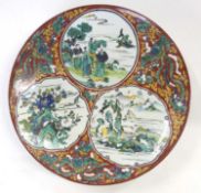Oriental pottery dish with three panels of design in famille verte amongst intricate floral borders,