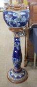 Royal Doulton jardiniere and stand, the blue ground with applied floral decoration, height overall