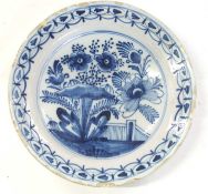 18th century Dutch Delft dish with floral design, 30cm diam (typical chips to rim)