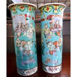 A pair of Chinese porcelain vases of cylindrical form, the green ground decorated with Chinese