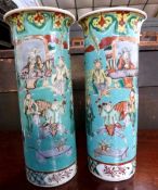 A pair of Chinese porcelain vases of cylindrical form, the green ground decorated with Chinese