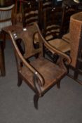 An unusual 19th Century scroll arm hard seat oak chair, the tips of each arm formed as a horses