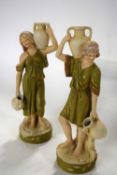 A pair of 20th Century Royal Dux ladies model as water carriers, 27cm high