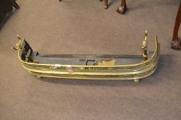 19th Century curved brass fire fender and accompanying set of tools, 104cm wide
