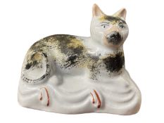 A 19th Century Staffordshire unusual model of a cat with a sponged design in black and ochre, 9cm