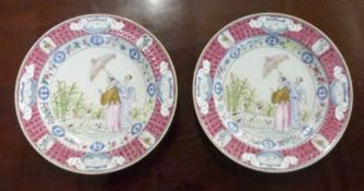 A pair of 20th Century Chinese porcelain plates with polychrome designs in the manner of Cornelius