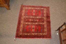 A Afghan Sharkh small rug or wall hanging decorated with geometric design on a red background, 85