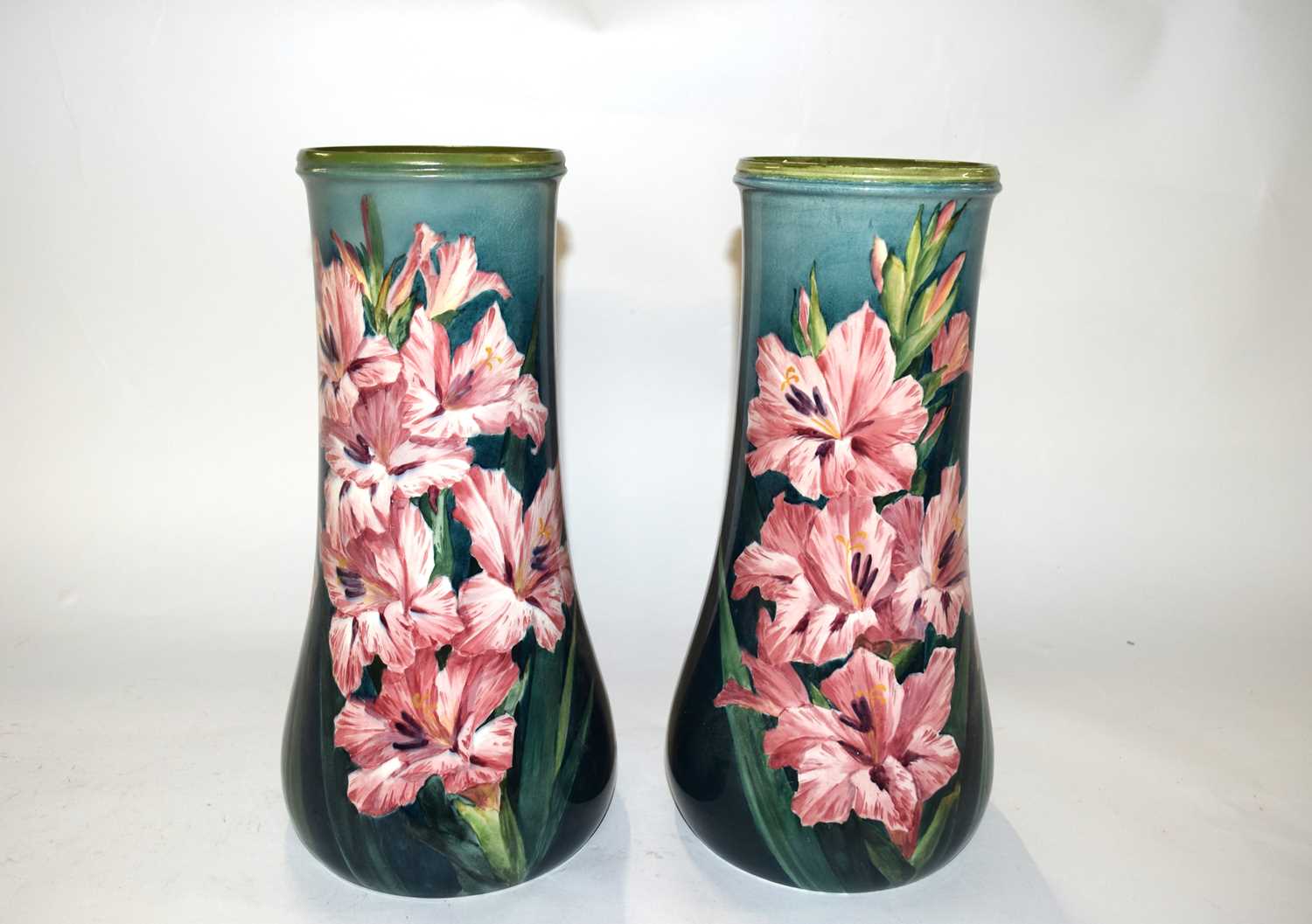 A pair of 19th Century Lambeth Faience vases decorated with pink flowers on green ground by Katie