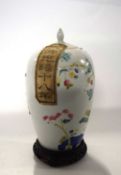 A late 19th Century Chinese porcelain jar and cover with famille rose design, 27cm high