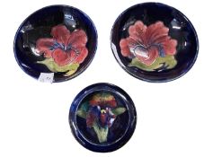 Group of three Moorcroft bowls, two with hibiscus designs and further small pin dish with an