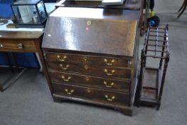 A small George III oak bureau of typical form with full front opening to an interior with pigeon
