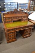 A Victorian gothic oak twin pedestal desk fitted with a top section with five small drawers over a