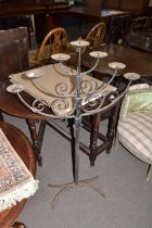 An iron floor standing seven light candelabra or menorah with spreading four footed base, 118cm