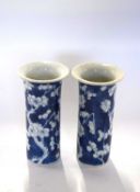 A pair of 19th Century Chinese porcelain vases of cylindrical form, the blue ground decorated with