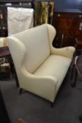 A Queen Anne style wing back two seater sofa on tapering legs