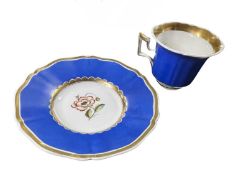 A Rockingham cup and saucer, the saucer with a painted floral design to the centre within blue
