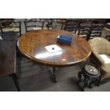 A Victorian rosewood circular top breakfast or dining table raised on a turned and carved column