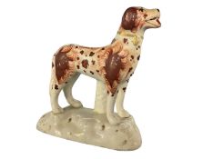 A 19th Century Staffordshire model of a dog with sponged decoration on shaped base, 9cm long