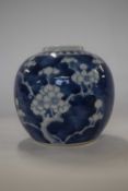 A Chinese porcelain ginger jar and cover, the blue ground with prunus decoration