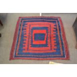 A Middle Eastern flat weave rug decorated with a large central blue and red geometric panel, 110 x