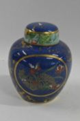 A Crown Devon jar and cover, the blue ground with a floral and bird design in gilt and enamel