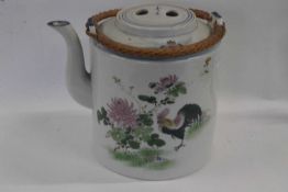 A large Oriental porcelain teapot with polychrome decoration of a chicken amongst foliage with