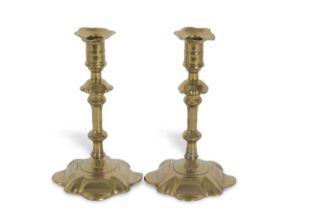 A pair of 18th Century brass candlesticks with petal formed spreading bases, 22cm high Possible